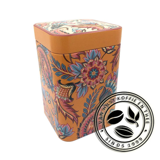 Blikje voor 100 gram thee met paisley motief. Achtergrondkleur van het blik is oranje, de motieven hebben de kleuren oranje, rood, roze, creme en blauw. Het deksel heeft aan de zijkanten dezelfde oranje kleur. De achtergrondkleur van het motief bovenop het deksel is creme.
