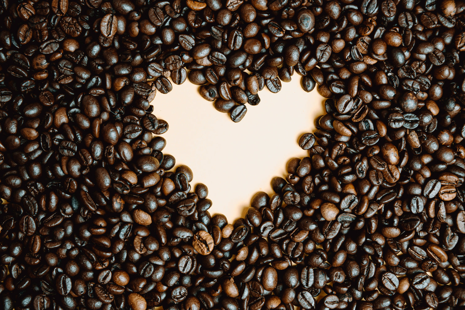 Coffee beans laid out in a heart shape.
